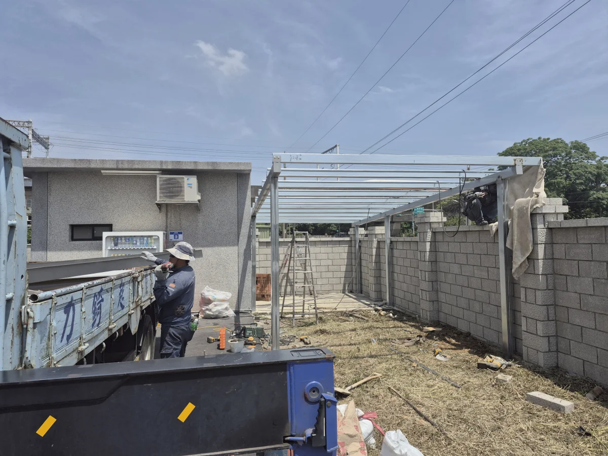 C型鋼雨遮施工中，組裝鍍鋁鋅浪板頂蓋與鋼構架，防護層完整
