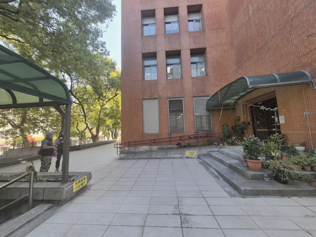 中壢教學樓戶外廣場，施工前原有鐵皮雨遮與植物盆栽景觀